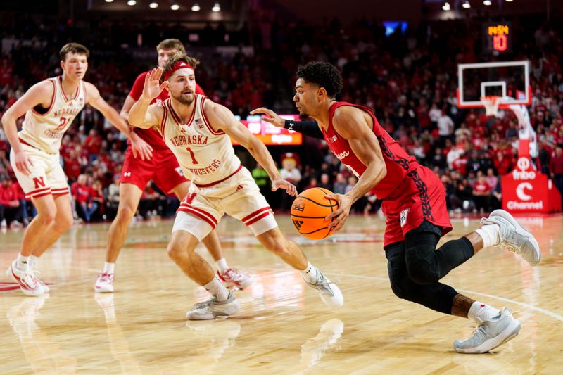 Dec 10, 2025; Lincoln, Nebraska, USA; Wisconsin Badgers guard Nick Boyd (2) drives against Nebraska Cornhuskers guard Sam Hoiberg (1) during the second half at Pinnacle Bank Arena. Mandatory Credit: Dylan Widger-Imagn Images