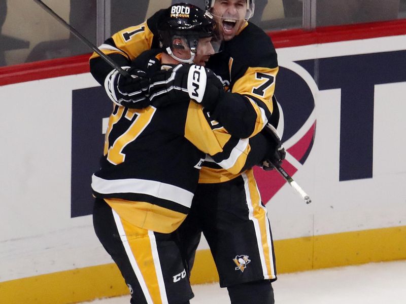 Oct 16, 2024; Pittsburgh, Pennsylvania, USA; Pittsburgh Penguins center Sidney Crosby (87) and center Evgeni Malkin (71) celebrate after Crosby scored the game winning power play goal in overtime to defeat the Buffalo Sabres at PPG Paints Arena. Mandatory Credit: Charles LeClaire-Imagn Images
