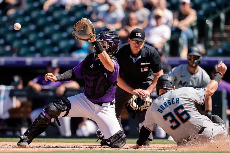 Aug 29, 2024; Denver, Colorado, USA; Miami Marlins first baseman Jake Burger (36) slides safely ahead of the tag from Colorado Rockies catcher Drew Romo (3) in the fourth inning at Coors Field. Mandatory Credit: Isaiah J. Downing-USA TODAY Sports