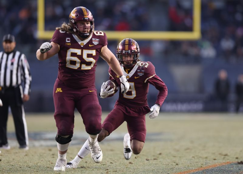 Dec 29, 2022; Bronx, NY, USA; Minnesota Golden Gophers wide receiver Daniel Jackson (9) carries the ball as offensive lineman Axel Ruschmeyer (65) blocks during the second half of the 2022 Pinstripe Bowl against the Syracuse Orange at Yankee Stadium. Mandatory Credit: Vincent Carchietta-USA TODAY Sports