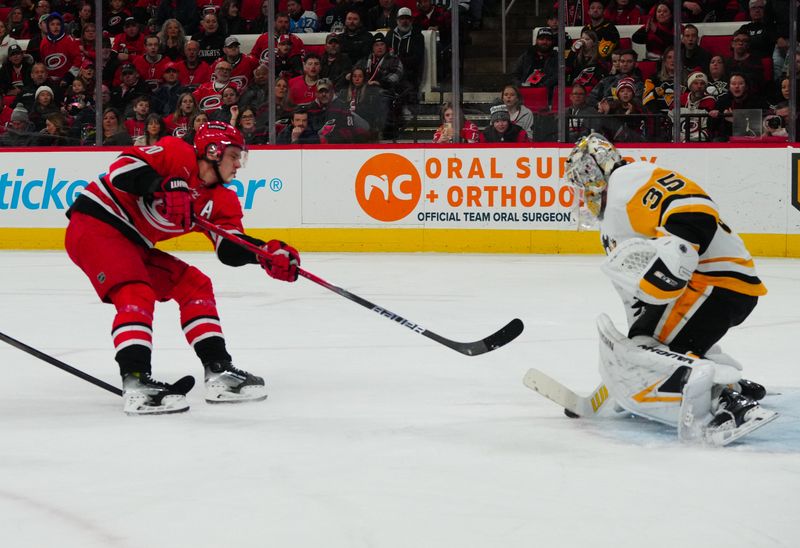 Jan 13, 2024; Raleigh, North Carolina, USA;  Pittsburgh Penguins goaltender Tristan Jarry (35) stops Carolina Hurricanes center Sebastian Aho (20) scoring attempt during the first period at PNC Arena. Mandatory Credit: James Guillory-USA TODAY Sports