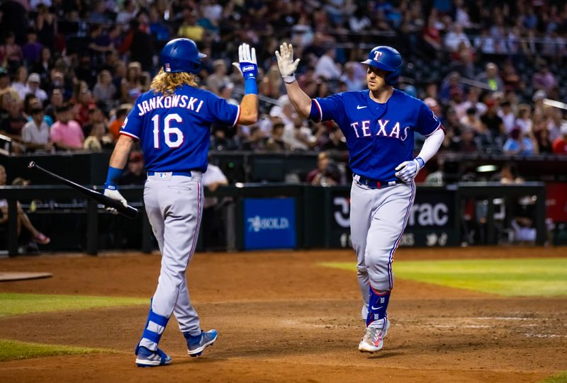 Aug 22, 2023; Phoenix, Arizona, USA; Texas Rangers catcher Mitch Garver (right) celebrates with teammate Travis Jankowski after hitting a solo home run in the sixth inning against the Arizona Diamondbacks at Chase Field. Mandatory Credit: Mark J. Rebilas-USA TODAY Sports