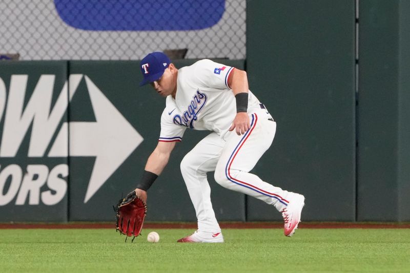 Apr 14, 2022; Arlington, Texas, USA; Texas Rangers right fielder Kole Calhoun (56) fields a single hit by Los Angeles Angels catcher Max Stassi (33) during the sixth inning of a baseball game at Globe Life Field. Mandatory Credit: Jim Cowsert-USA TODAY Sports