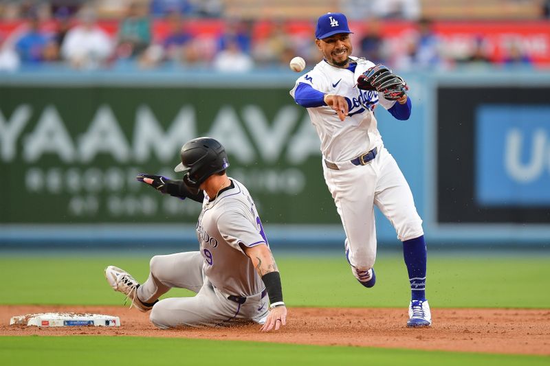 May 31, 2024; Los Angeles, California, USA; Colorado Rockies center fielder Brenton Doyle (9) is out at second as Los Angeles Dodgers shortstop Mookie Betts (50) throws to first for the out against Colorado Rockies left fielder Jake Cave (11) during the second inning at Dodger Stadium. Mandatory Credit: Gary A. Vasquez-USA TODAY Sports