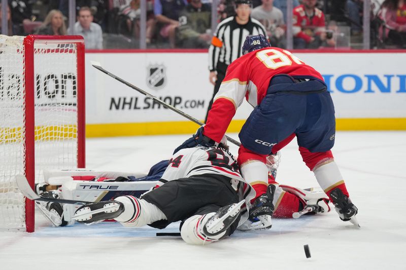 Feb 1, 2025; Sunrise, Florida, USA;  Chicago Blackhawks left wing Landon Slaggert (84) collides with Florida Panthers goaltender Sergei Bobrovsky (72) as defenseman Nate Schmidt (88) defends on the play in the first period at Amerant Bank Arena. Mandatory Credit: Jim Rassol-Imagn Images