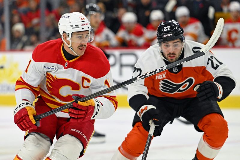 Nov 2, 2025; Philadelphia, Pennsylvania, USA; Calgary Flames center Mikael Backlund (11) skates against Philadelphia Flyers left wing Noah Cates (27)  during the first period at Xfinity Mobile Arena. Mandatory Credit: Eric Hartline-Imagn Images