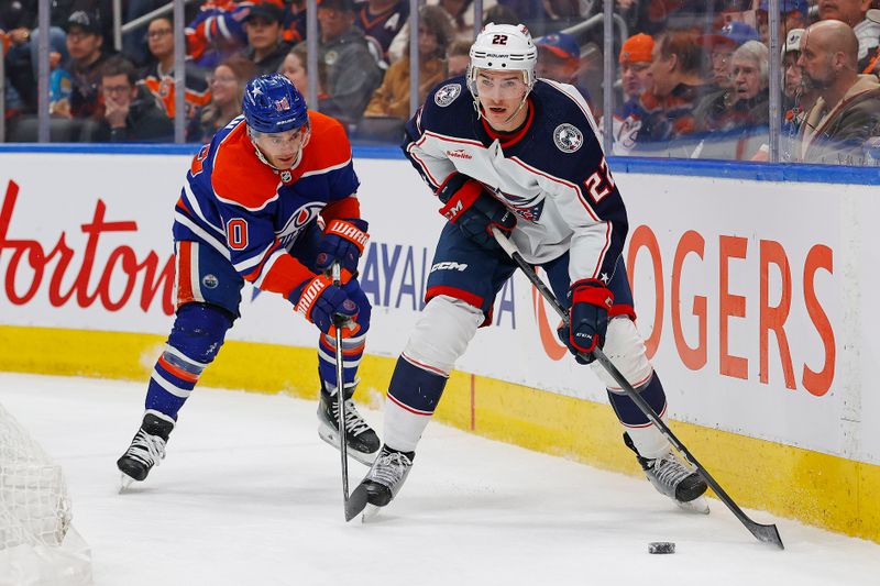 Jan 23, 2024; Edmonton, Alberta, CAN; Columbus Blue Jackets defensemen Jake Bean moves the puck in front of Edmonton Oilers forward Derek Ryan (10) during the first period at Rogers Place. Mandatory Credit: Perry Nelson-USA TODAY Sports