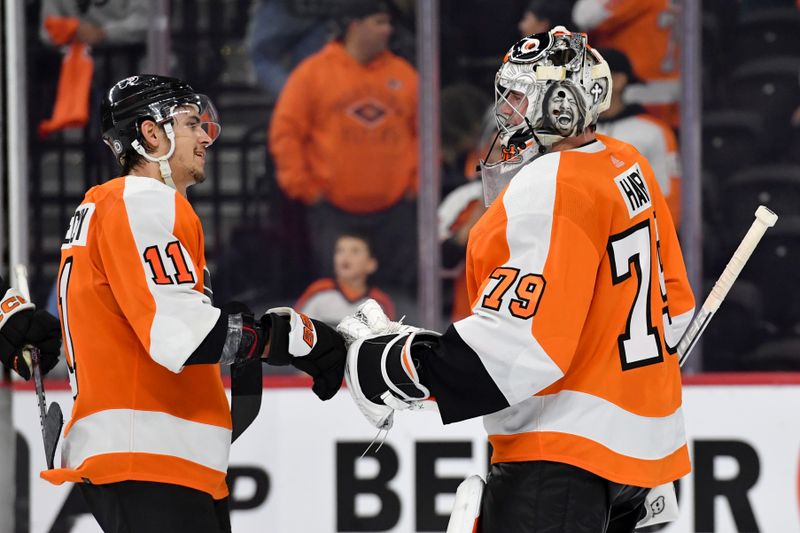 Oct 13, 2022; Philadelphia, Pennsylvania, USA; Philadelphia Flyers right wing Travis Konecny (11) and  goaltender Carter Hart (79) celebrate win against the New Jersey Devils at Wells Fargo Center. Mandatory Credit: Eric Hartline-USA TODAY Sports