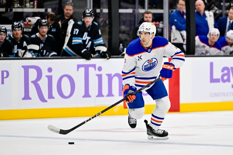 Nov 29, 2024; Salt Lake City, Utah, USA; Edmonton Oilers defenseman Evan Bouchard (2) moves the puck down the ice against the Utah Hockey Club during the third period at the Delta Center. Mandatory Credit: Christopher Creveling-Imagn Images