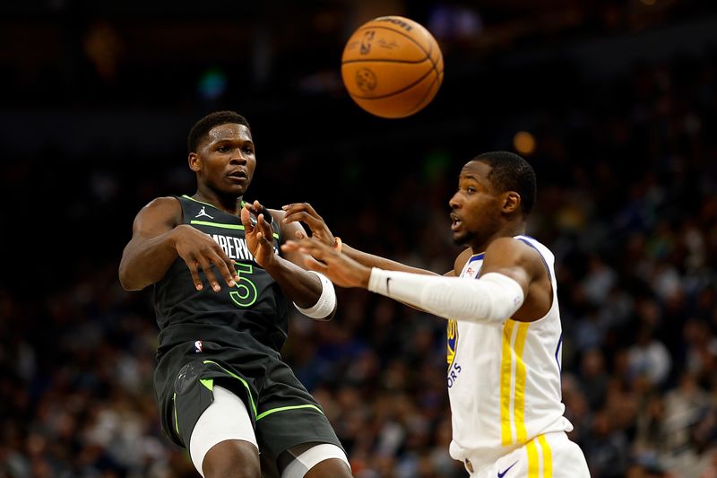 MINNEAPOLIS, MINNESOTA - MARCH 24: Anthony Edwards #5 of the Minnesota Timberwolves passes the ball against Jonathan Kuminga #00 of the Golden State Warriors in the third quarter at Target Center on March 24, 2024 in Minneapolis, Minnesota. The Timberwolves defeated the Warriors 114-110. NOTE TO USER: User expressly acknowledges and agrees that, by downloading and or using this photograph, User is consenting to the terms and conditions of the Getty Images License Agreement. (Photo by David Berding/Getty Images)