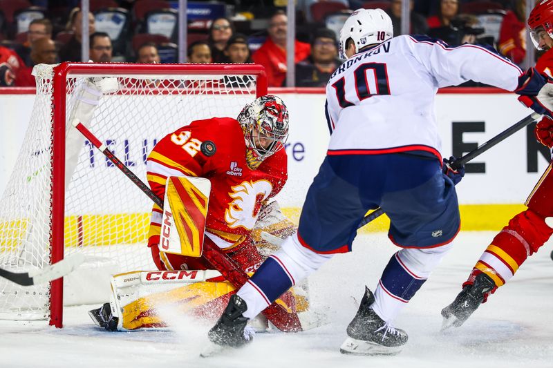 Nov 5, 2025; Calgary, Alberta, CAN; Calgary Flames goaltender Dustin Wolf (32) makes a save against Columbus Blue Jackets left wing Dmitri Voronkov (10) during the third period at Scotiabank Saddledome. Mandatory Credit: Sergei Belski-Imagn Images