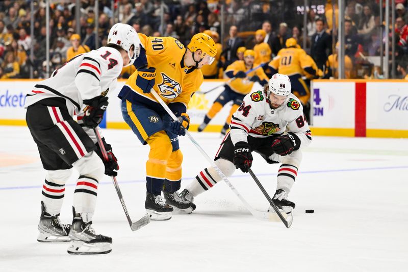 Jan 10, 2026; Nashville, Tennessee, USA;  Nashville Predators center Fedor Svechkiv (40) skates between Chicago Blackhawks defenseman Kevin Korchinski (14) and left wing Landon Slaggert (84) during the third period at Bridgestone Arena. Mandatory Credit: Steve Roberts-Imagn Images