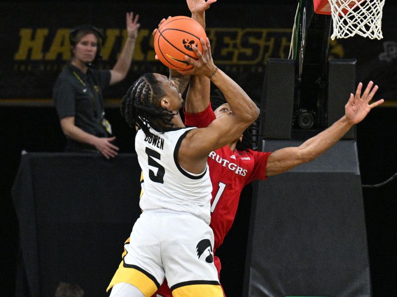 Jan 6, 2024; Iowa City, Iowa, USA; Iowa Hawkeyes guard Dasonte Bowen (5) goes to the basket as Rutgers Scarlet Knights guard Jamichael Davis (1) defends during the first half at Carver-Hawkeye Arena. Mandatory Credit: Jeffrey Becker-USA TODAY Sports