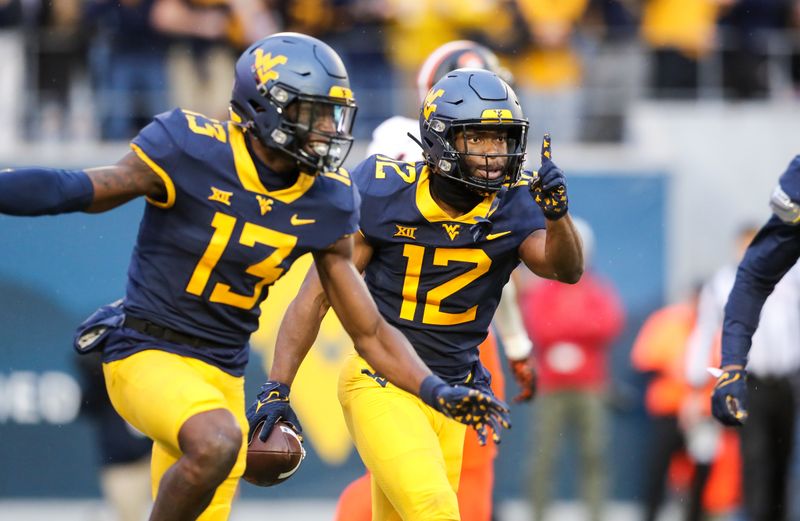 Oct 21, 2023; Morgantown, West Virginia, USA; West Virginia Mountaineers safety Anthony Wilson (12) intercepts a pass and celebrates during the third quarter against the Oklahoma State Cowboys at Mountaineer Field at Milan Puskar Stadium. Mandatory Credit: Ben Queen-USA TODAY Sports