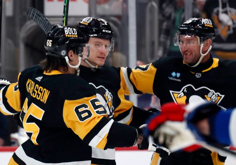 Mar 16, 2024; Pittsburgh, Pennsylvania, USA;  Pittsburgh Penguins defenseman Erik Karlsson (65) and center Jeff Carter (77) congratulate defenseman John Ludvig (middle) after he scored a goal against the New York Rangers during the first period at PPG Paints Arena. Mandatory Credit: Charles LeClaire-USA TODAY Sports