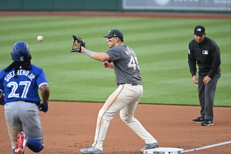 May 3, 2024; Washington, District of Columbia, USA; Washington Nationals first baseman Joey Meneses (45) catches the ball at first base in front of Toronto Blue Jays first baseman Vladimir Guerrero Jr. (27) for an out during the second inning at Nationals Park. Mandatory Credit: Rafael Suanes-USA TODAY Sports