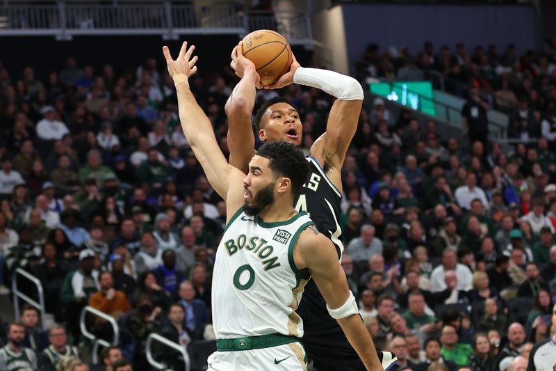 MILWAUKEE, WISCONSIN - JANUARY 11: Giannis Antetokounmpo #34 of the Milwaukee Bucks is defended by Jayson Tatum #0 of the Boston Celtics during a game at Fiserv Forum on January 11, 2024 in Milwaukee, Wisconsin.  The Bucks defeated the Celtics 135 - 102.  NOTE TO USER: User expressly acknowledges and agrees that, by downloading and or using this photograph, User is consenting to the terms and conditions of the Getty Images License Agreement. (Photo by Stacy Revere/Getty Images)