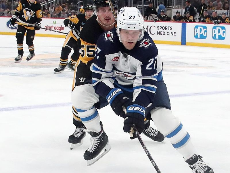 Nov 22, 2024; Pittsburgh, Pennsylvania, USA;  Winnipeg Jets left wing Nikolaj Ehlers (27) reaches for the puck ahead of Pittsburgh Penguins center Noel Acciari (55) during the third period at PPG Paints Arena. Mandatory Credit: Charles LeClaire-Imagn Images
