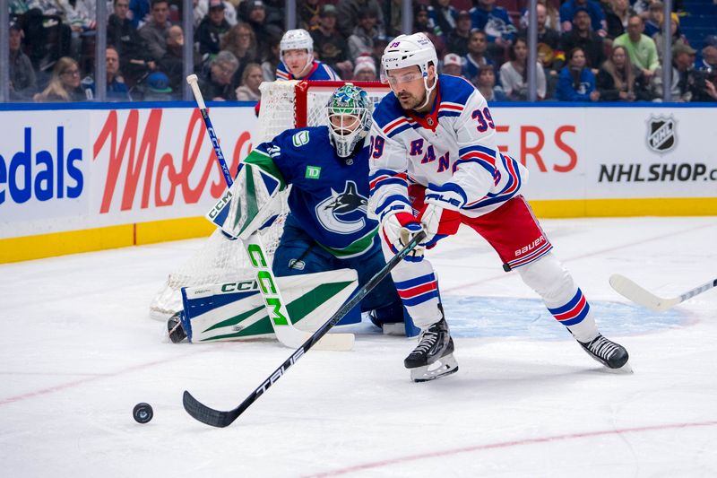 Nov 19, 2024; Vancouver, British Columbia, CAN; Vancouver Canucks goalie Arturs Silovs (31) watches as New York Rangers forward Sam Carrick (39) reaches for the puck during the first period at Rogers Arena. Mandatory Credit: Bob Frid-Imagn Images