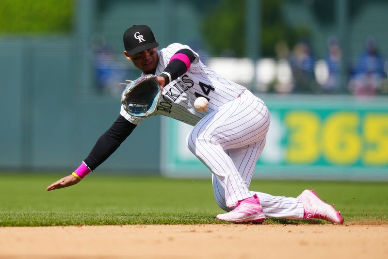 May 12, 2024; Denver, Colorado, USA; Colorado Rockies shortstop Ezequiel Tovar (14) fields the ball in the seventh inning against the Texas Rangers at Coors Field. Mandatory Credit: Ron Chenoy-USA TODAY Sports