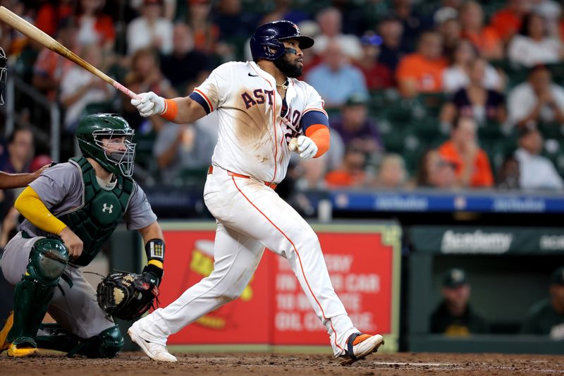 Sep 12, 2024; Houston, Texas, USA; Houston Astros first baseman Jon Singleton (28) hits an RBI single against the Oakland Athletics during the eighth inning at Minute Maid Park. Mandatory Credit: Erik Williams-Imagn Images
