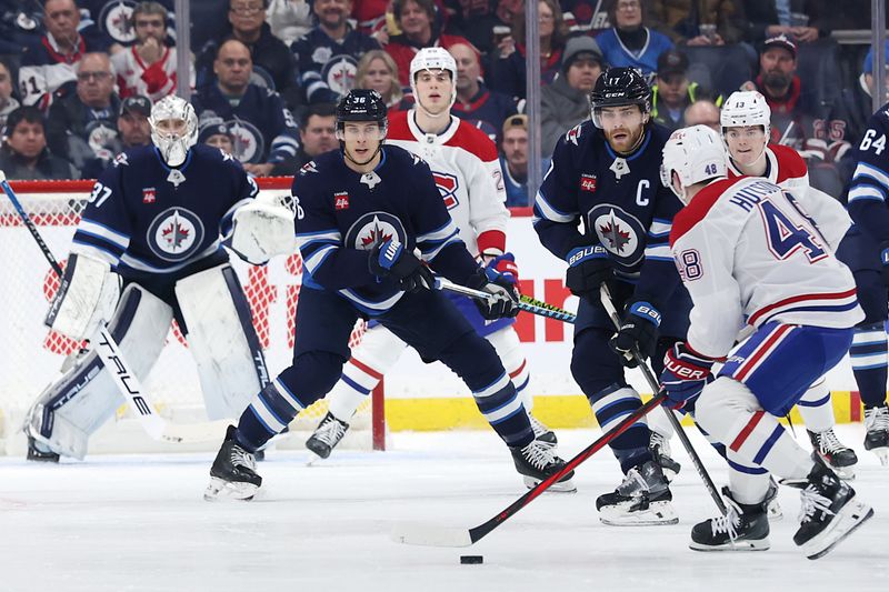 Dec 14, 2024; Winnipeg, Manitoba, CAN; Winnipeg Jets center Morgan Barron (36) and Winnipeg Jets center Adam Lowry (17) get set to block a shot by Montreal Canadiens defenseman Lane Hutson (48) in the second period at Canada Life Centre. Mandatory Credit: James Carey Lauder-Imagn Images