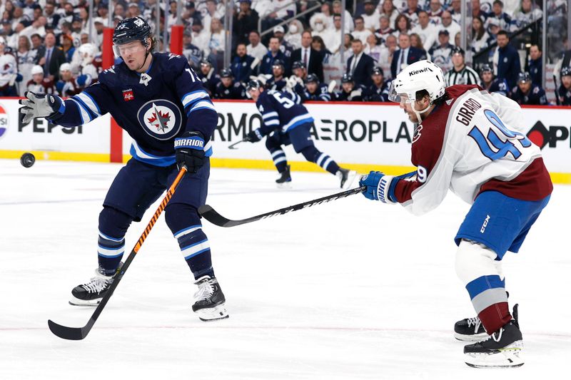 Apr 30, 2024; Winnipeg, Manitoba, CAN; Colorado Avalanche defenseman Samuel Girard (49) flips the puck past Winnipeg Jets center Tyler Toffoli (73) in the second period in game five of the first round of the 2024 Stanley Cup Playoffs at Canada Life Centre. Mandatory Credit: James Carey Lauder-USA TODAY Sports