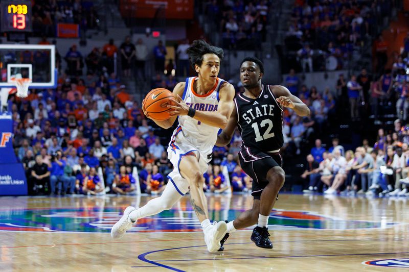 Mar 3, 2026; Gainesville, Florida, USA; Florida Gators guard Xaivian Lee (1) dribbles the ball past Mississippi State Bulldogs guard Josh Hubbard (12) during the second half at Exactech Arena at the Stephen C. O'Connell Center. Mandatory Credit: Morgan Tencza-Imagn Images