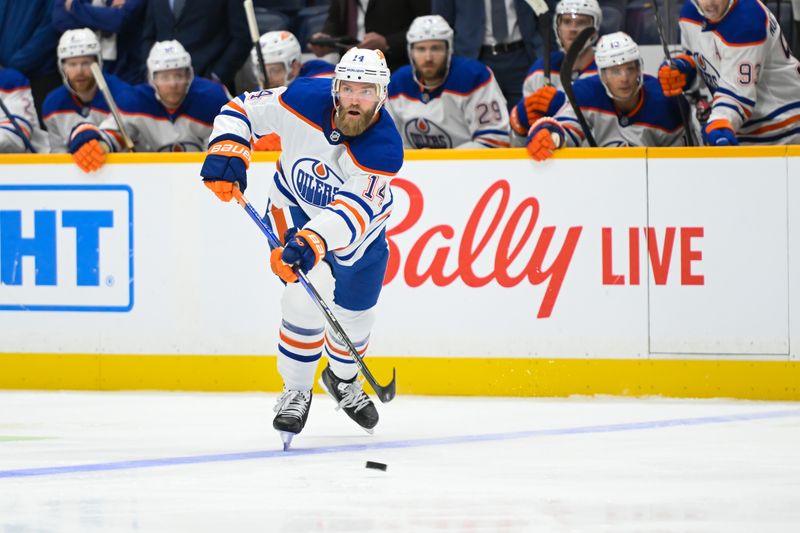 Oct 17, 2024; Nashville, Tennessee, USA;  Edmonton Oilers defenseman Mattias Ekholm (14) passes the puck against the Nashville Predators during the second period at Bridgestone Arena. Mandatory Credit: Steve Roberts-Imagn Images