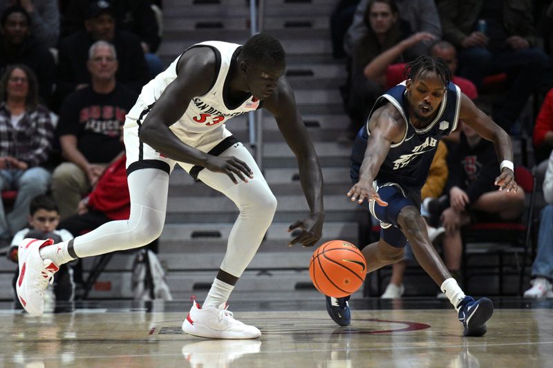 Jan 25, 2023; San Diego, California, USA; San Diego State Aztecs forward Aguek Arop (33) and Utah State Aggies forward Zee Hamoda (24) battle for a loose ball during the second half at Viejas Arena. Mandatory Credit: Orlando Ramirez-USA TODAY Sports