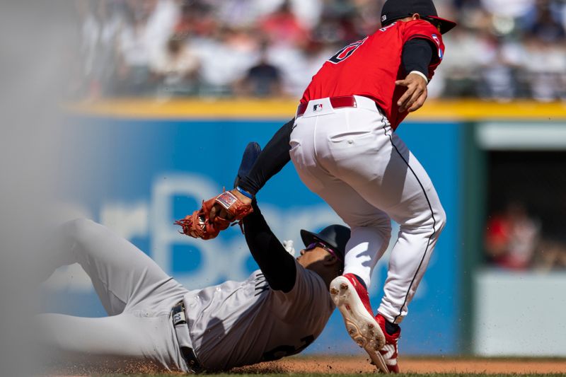 Apr 14, 2024; Cleveland, Ohio, USA; New York Yankees right fielder Juan Soto (22) is tagged out by Cleveland Guardians second baseman Andres Gimenez (0) as he slides into second base during the fifth inning at Progressive Field. Mandatory Credit: Scott Galvin-USA TODAY Sports