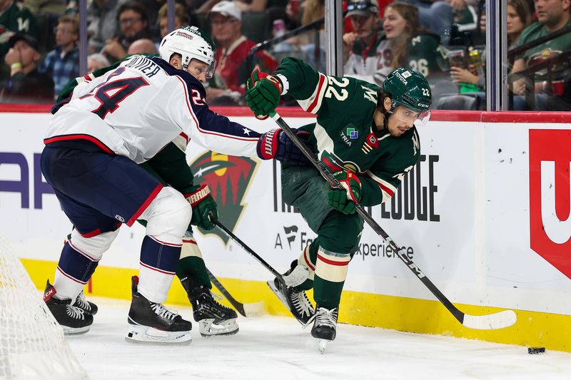 Oct 10, 2024; Saint Paul, Minnesota, USA; Minnesota Wild center Marat Khusnutdinov (22) skates with the puck as Columbus Blue Jackets right wing Mathieu Olivier (24) defends during the third period at Xcel Energy Center. Mandatory Credit: Matt Krohn-Imagn Images