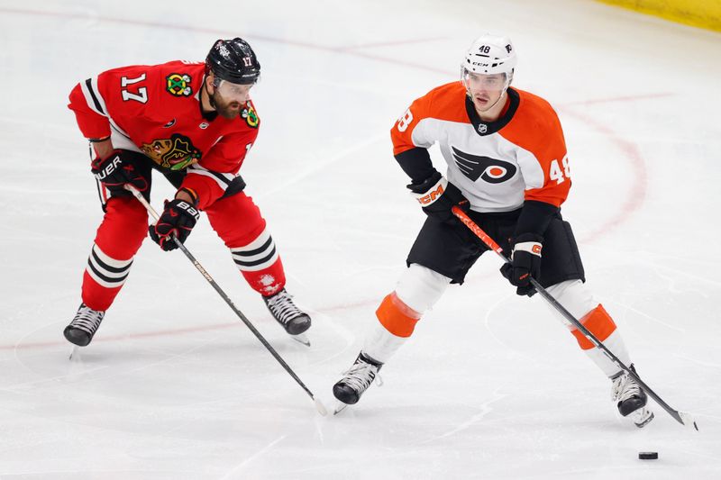 Feb 21, 2024; Chicago, Illinois, USA; Philadelphia Flyers center Morgan Frost (48) looks to pass the puck against Chicago Blackhawks left wing Nick Foligno (17) during the second period at United Center. Mandatory Credit: Kamil Krzaczynski-USA TODAY Sports