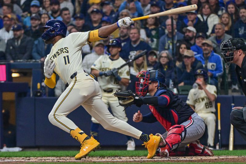 Apr 2, 2024; Milwaukee, Wisconsin, USA; Milwaukee Brewers center fielder Jackson Chourio (11) hits a single to drive in a run in the second inning as Minnesota Twins catcher Christian Vazquez (8) looks on at American Family Field. Mandatory Credit: Benny Sieu-USA TODAY Sports