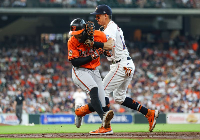 Jun 22, 2024; Houston, Texas, USA; Baltimore Orioles third baseman Ramon Urias (29) is tagged in the face by Houston Astros first baseman Mauricio Dubon (14) on a play during the third inning at Minute Maid Park. Mandatory Credit: Troy Taormina-USA TODAY Sports