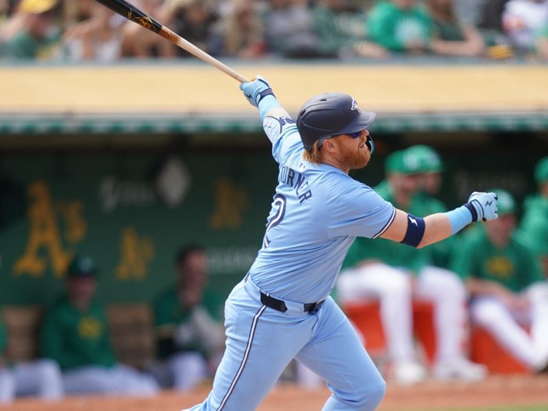 Jun 8, 2024; Oakland, California, USA; Toronto Blue Jays designated hitter Justin Turner (2) hits an RBI single against the Oakland Athletics in the ninth inning at Oakland-Alameda County Coliseum. Mandatory Credit: Cary Edmondson-USA TODAY Sports