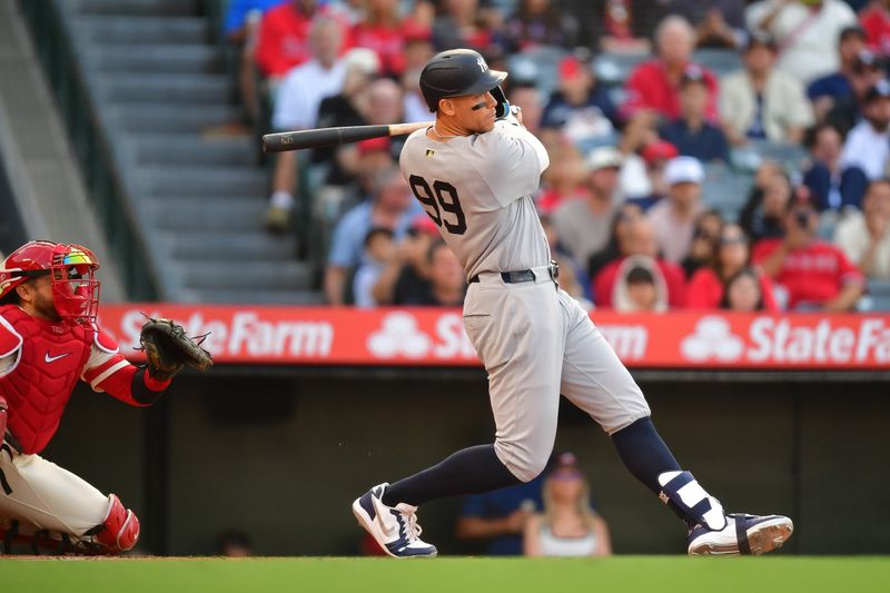 May 27, 2025; Anaheim, California, USA; New York Yankees right fielder Aaron Judge (99) hits a single against the Los Angeles Angels during the first inning at Angel Stadium. Mandatory Credit: Gary A. Vasquez-Imagn Images