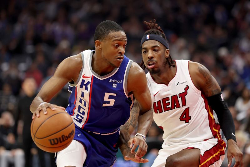 SACRAMENTO, CALIFORNIA - FEBRUARY 26: De'Aaron Fox #5 of the Sacramento Kings is guarded by Delon Wright #4 of the Miami Heat in the first half at Golden 1 Center on February 26, 2024 in Sacramento, California. NOTE TO USER: User expressly acknowledges and agrees that, by downloading and or using this photograph, User is consenting to the terms and conditions of the Getty Images License Agreement.  (Photo by Ezra Shaw/Getty Images)