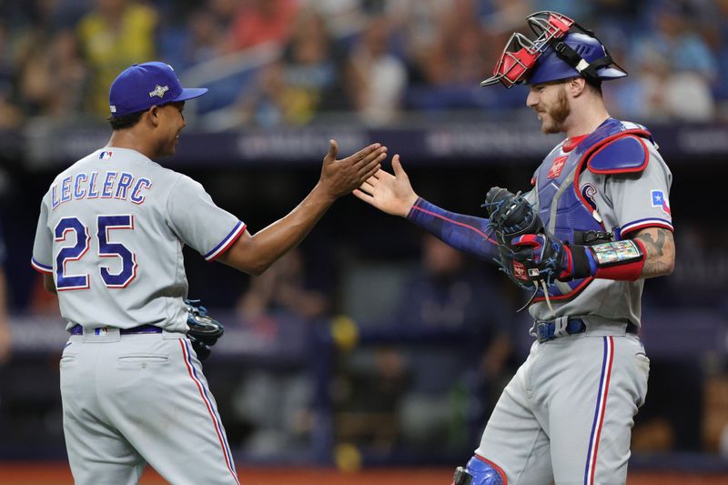 Oct 4, 2023; St. Petersburg, Florida, USA; Texas Rangers relief pitcher Jose Leclerc (25) celebrates with catcher Jonah Heim (28) after recording the final out against the Tampa Bay Rays in the ninth inning during game two of the Wildcard series for the 2023 MLB playoffs at Tropicana Field. Mandatory Credit: Nathan Ray Seebeck-USA TODAY Sports