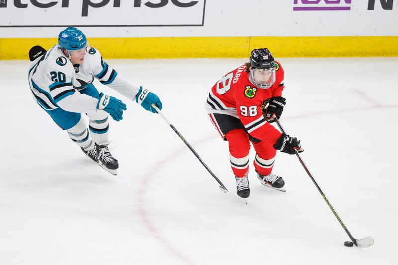 Mar 17, 2024; Chicago, Illinois, USA; Chicago Blackhawks center Connor Bedard (98) controls the puck against San Jose Sharks left wing Fabian Zetterlund (20) during the third period at United Center. Mandatory Credit: Kamil Krzaczynski-USA TODAY Sports