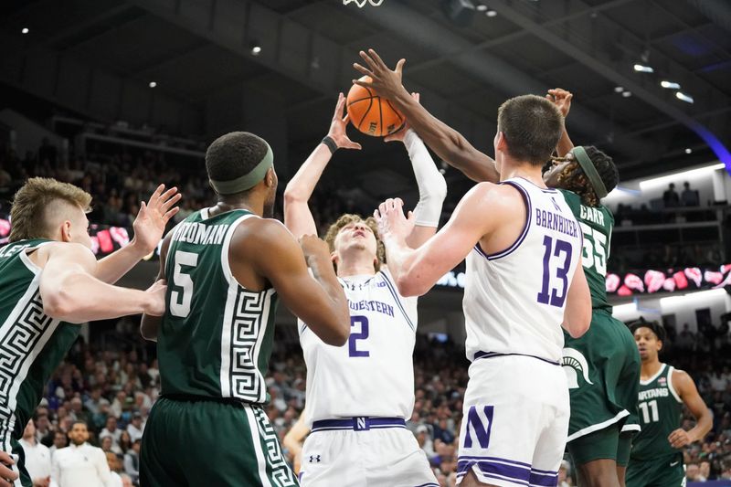 Jan 7, 2024; Evanston, Illinois, USA; Michigan State Spartans guard Tre Holloman (5) defends Northwestern Wildcats forward Nick Martinelli (2) during the second half at Welsh-Ryan Arena. Mandatory Credit: David Banks-USA TODAY Sports