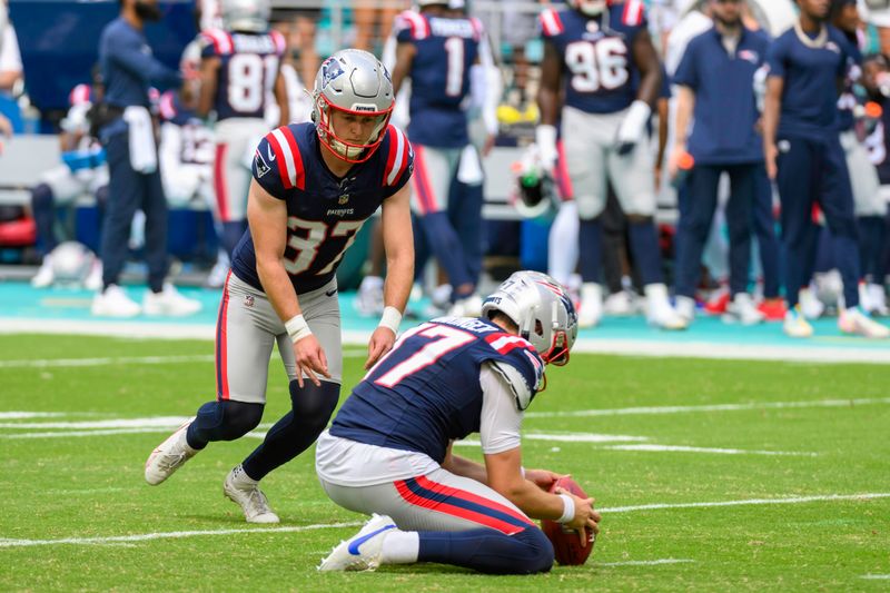 New England Patriots punter Bryce Baringer (17) holds the ball as New England Patriots kicker Chad Ryland (37) kicks for an extra point during an NFL football game against the Miami Dolphins, Sunday, Oct. 29, 2023, in Miami Gardens, Fla. (AP Photo/Doug Murray)