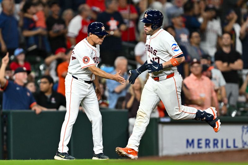 Jun 25, 2025; Houston, Texas, USA; Houston Astros third base coach Tony Perezchica (12) high fives catcher Victor Caratini (17) after hitting a solo home run in the eighth inning against the Philadelphia Phillies at Daikin Park. Mandatory Credit: Maria Lysaker-Imagn Images 
