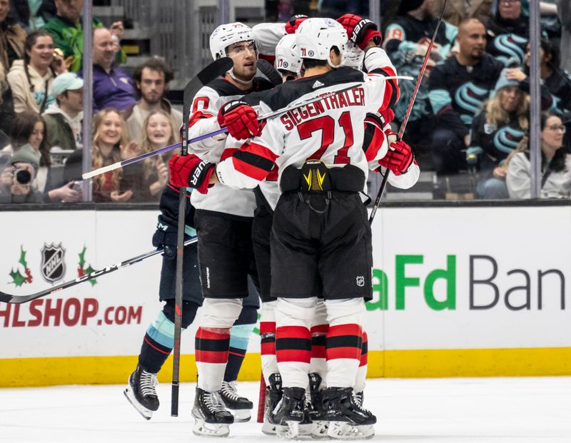 Dec 7, 2023; Seattle, Washington, USA; New Jersey Devils including forward Michael McLeod (20), left, defenseman Jonas Siegenthaler (71) celebrate a goald during the second period against the Seattle Kraken at Climate Pledge Arena. Mandatory Credit: Stephen Brashear-USA TODAY Sports