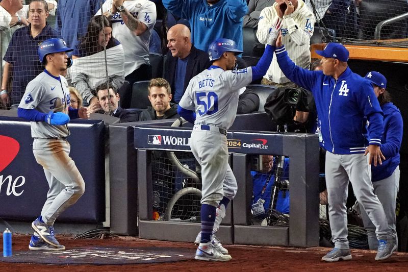 Oct 30, 2024; New York, New York, USA; Los Angeles Dodgers manager Dave Roberts (30) celebrates with shortstop Mookie Betts (50) after he hit a sacrifice fly during the eighth inning against the New York Yankees in game four of the 2024 MLB World Series at Yankee Stadium. Mandatory Credit: Robert Deutsch-Imagn Images
