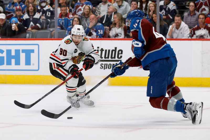 Oct 19, 2023; Denver, Colorado, USA; Colorado Avalanche defenseman Josh Manson (42) controls the puck as Chicago Blackhawks center Tyler Johnson (90) defends in the first period at Ball Arena. Mandatory Credit: Isaiah J. Downing-USA TODAY Sports