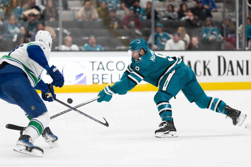 Nov 2, 2023; San Jose, California, USA; Vancouver Canucks defenseman Tyler Myers (57) defects the puck from San Jose Sharks defenseman Jacob MacDonald (9) during the second period at SAP Center at San Jose. Mandatory Credit: Stan Szeto-USA TODAY Sports