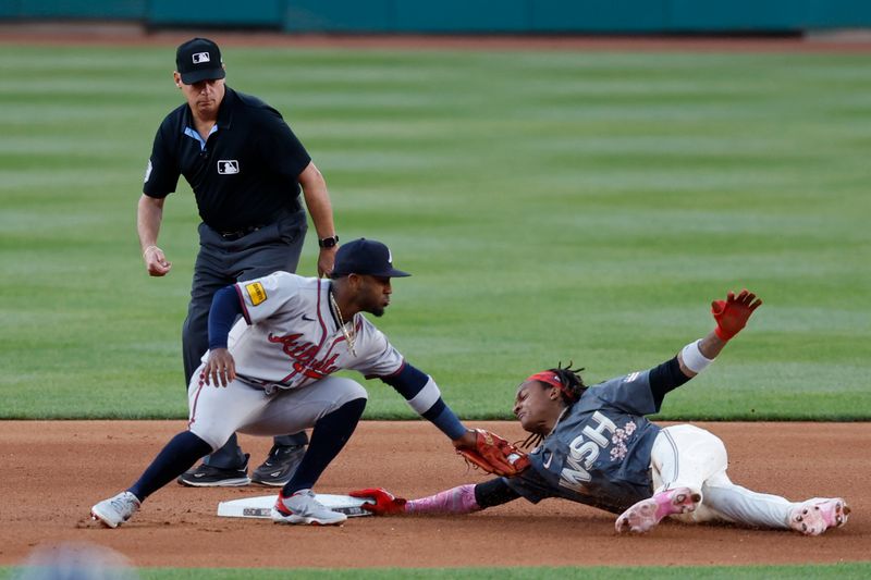 Jun 7, 2024; Washington, District of Columbia, USA; Washington Nationals shortstop CJ Abrams (5) dives into second base with a double ahead of a tag by Atlanta Braves second baseman Ozzie Albies (1) during the fourth inning at Nationals Park. Mandatory Credit: Geoff Burke-USA TODAY Sports