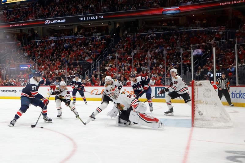 Mar 9, 2024; Washington, District of Columbia, USA; Washington Capitals defenseman Trevor van Riemsdyk (57) shoots the puck on Chicago Blackhawks goaltender Petr Mrazek (34) in the second period at Capital One Arena. Mandatory Credit: Geoff Burke-USA TODAY Sports