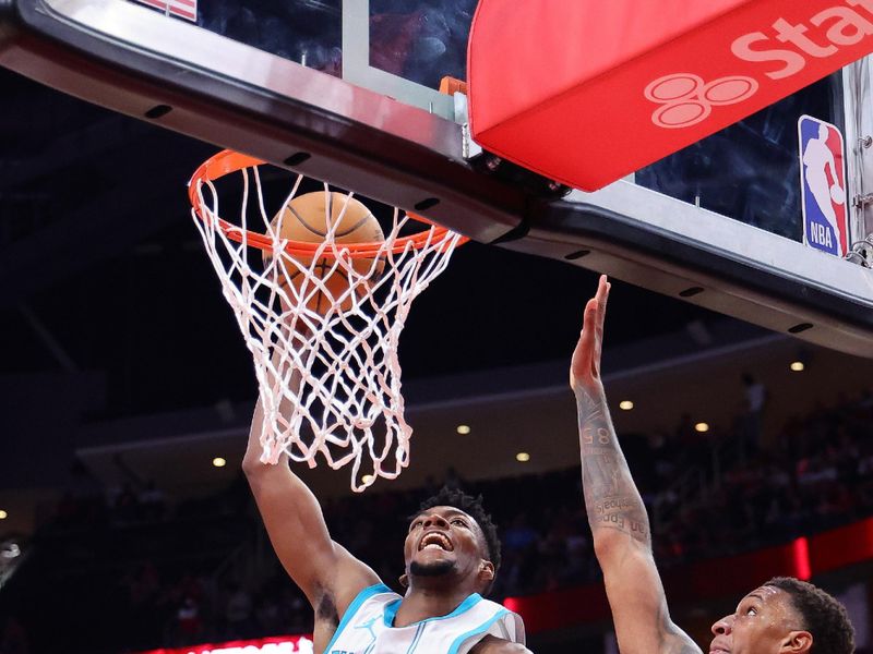 HOUSTON, TEXAS - OCTOBER 23: Brandon Miller #24 of the Charlotte Hornets slam dunks the ball over Alperen Sengun #28 of the Houston Rockets and Jabari Smith Jr. #10 during the first half at Toyota Center on October 23, 2024 in Houston, Texas.  NOTE TO USER: User expressly acknowledges and agrees that, by downloading and or using this photograph, User is consenting to the terms and conditions of the Getty Images License Agreement. (Photo by Alex Slitz/Getty Images)